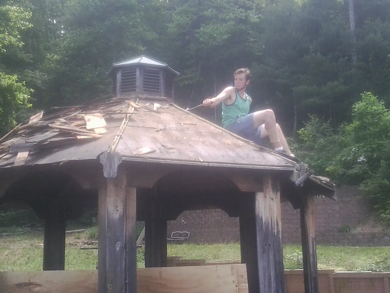 Tearing the old roof off a wooden gazebo before new shakes in Desmet