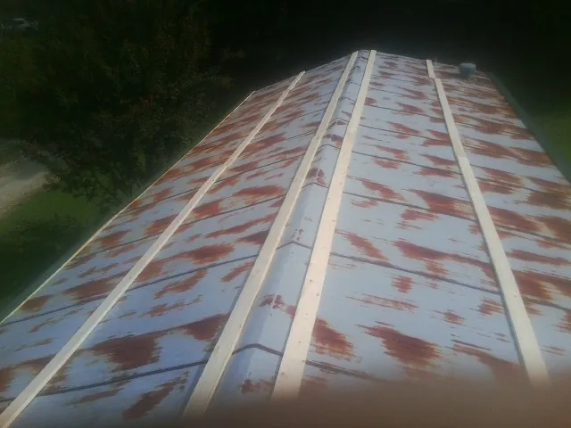 Rusted metal roof panels with new wood purlins before replacement — Storm Damage Roof Repair in Desmet by Roofing Brothers