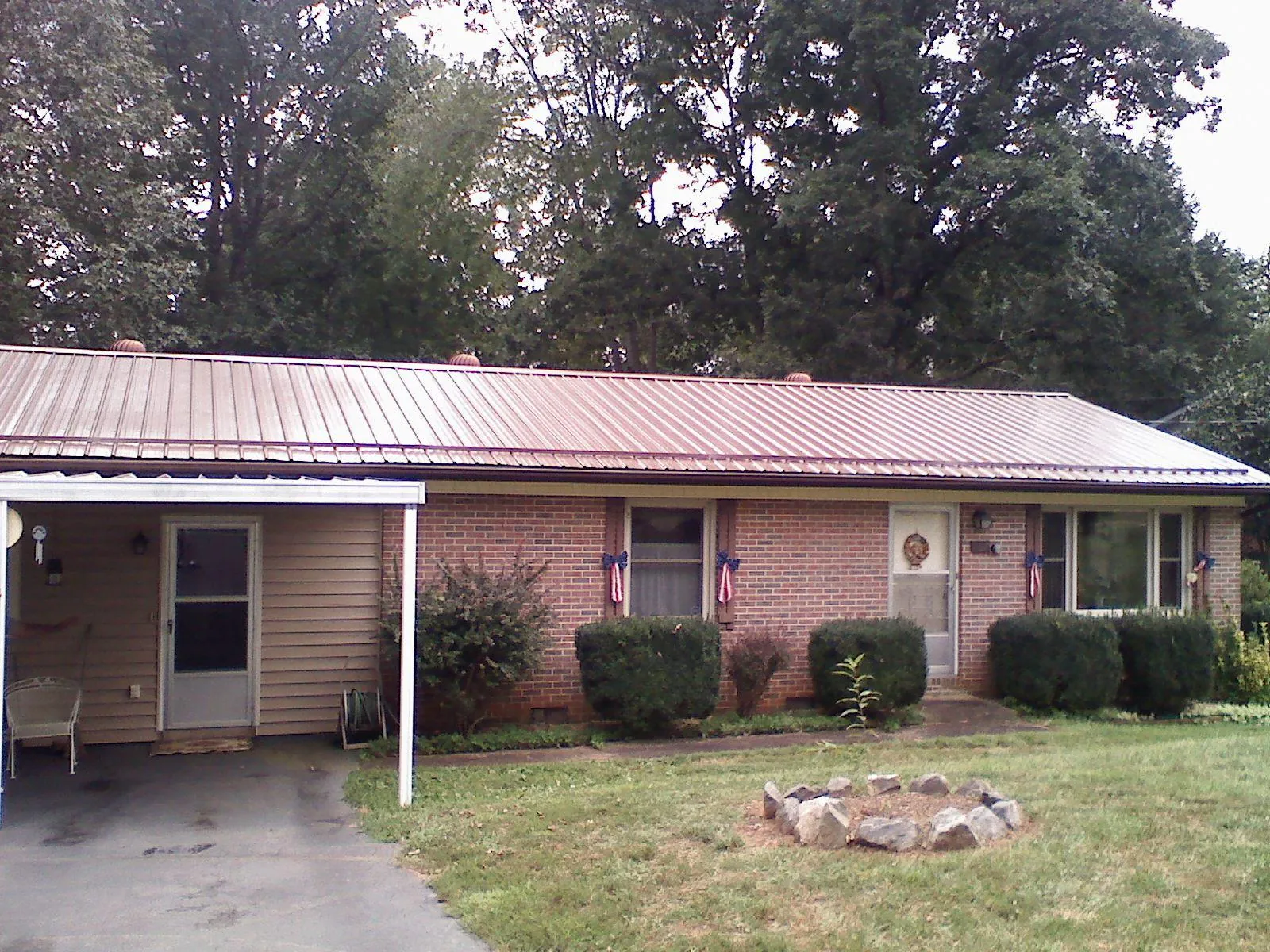 Bronze metal roof and carport on a brick ranch home — Roof Repair work by our crew in Desmet